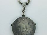 an old coin with a keychain hanging from it ' s side