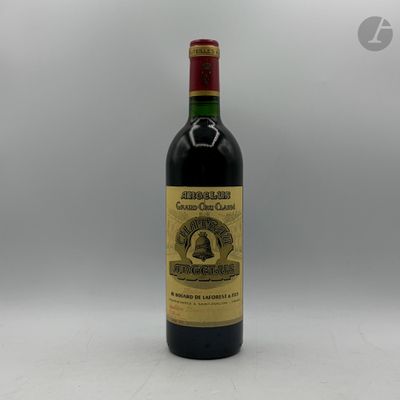 une bouteille de vin posée sur une table blanche