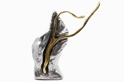 a close up of a silver and gold sculpture on a white background