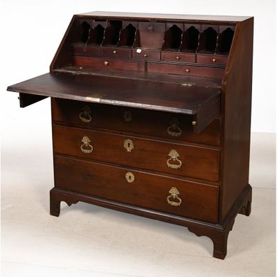 un bureau ancien en bois, doté de ferrures en laiton et de tiroirs