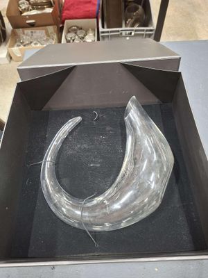 un objet en verre transparent dans une boîte posée sur une table