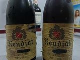 two bottles of wine sitting on a counter top