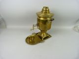 a small brass coffee pot on a white surface