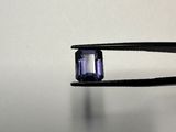 quelqu'un tient une pince sur laquelle est sertie une pierre violette