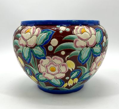 a vase with flowers painted on it sitting on a table
