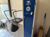 a blue locker in the corner of a room next to a chair