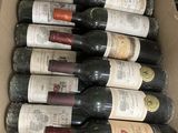 many bottles of wine in a cardboard box on the counter