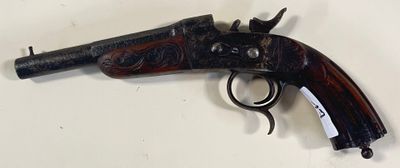 un vieux pistolet accroché au mur, avec une étiquette attachée dessus