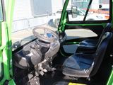 a green vehicle with a steering and a steering wheel