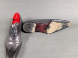 pair of black and silver shoes with red soles on a gray surface