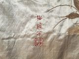 a white cloth with a picture of a bird and flowers on it