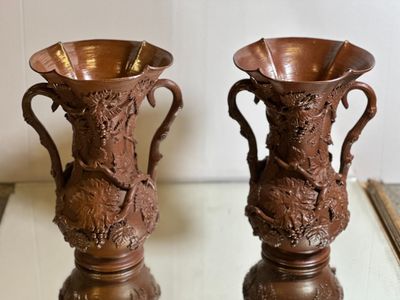 two brown vases sitting on a table next to each other