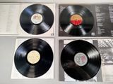 three black vinyl records are on display on a table