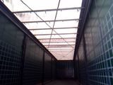 a long hallway with green walls and a skylight above it