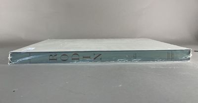 an open book sitting on top of a table next to a white wall
