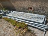 a metal bench sitting on the side of a building