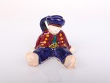 a small figurine of a man sitting on the ground