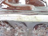 a close up of a glass vase with a bird on it