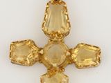 a close up of a cross made out of yellow crystals
