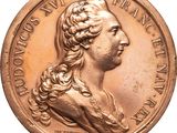 l'image d'une médaille d'or sur laquelle figure le visage d'une femme