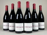 six bouteilles de vin sont alignées dans une rangée