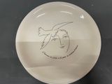 a white plate with a drawing of a bird on it