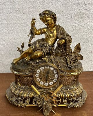 une horloge en or posée sur une table en bois