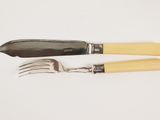 two forks and a knife on a white surface