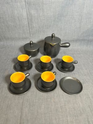 une image représentant un ensemble de tasses et de soucoupes posées sur une table