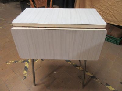 a small white table with a wooden top on a tile floor