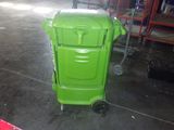 a green trash can sitting in the middle of a warehouse