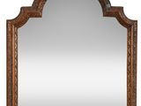 a large wooden mirror with an ornate design on the top
