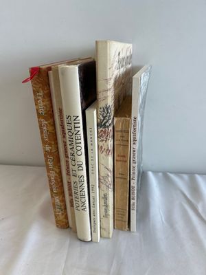 several books are stacked on top of each other on a bed