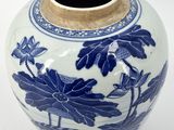 a blue and white vase with flowers and leaves on it