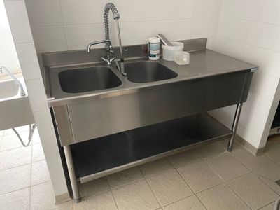 deux lavabos dans la salle de bains, avec un robinet et un distributeur de savon posés sur le plan de travail