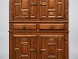 une grande armoire en chêne avec des panneaux sculptés et une porte