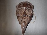 un masque en bois accroché au mur d'une pièce