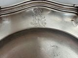 a silver plate with a decorative design on it