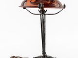 a lamp with a glass shade on top of it next to a wire