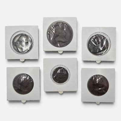 six sortes de chocolats dans une boîte blanche posée sur une surface blanche