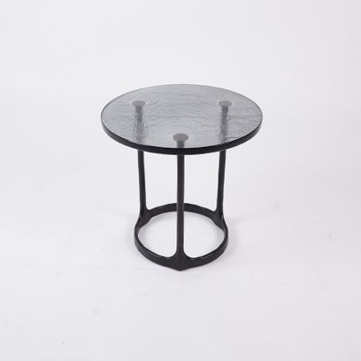 a black side table with a glass top on a white background