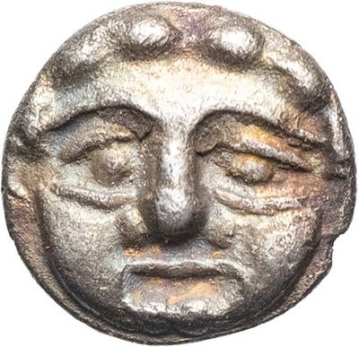 a close up of a coin with a face on it