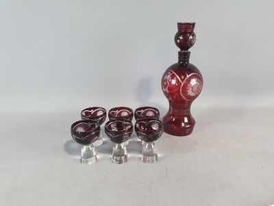 cinq verres et une bouteille de vin sur une table