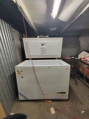 a refrigerator and freezer in a room with a lot of junk