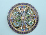 an image of a gold and enamel broochle on a white surface