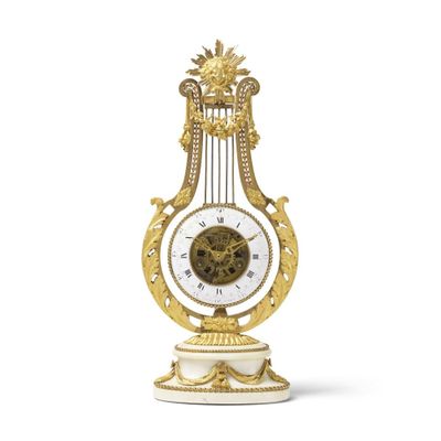 une horloge dorée et blanche posée sur un socle, sur une surface blanche