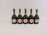 four bottles of champagne are lined up on a white surface