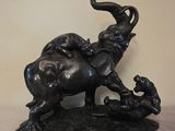 une statue représentant un éléphant et un chien sur un rocher
