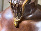 a bronze statue of a man with a hat on his head