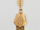 Gros plan sur un pendentif en or orné d'un oiseau
